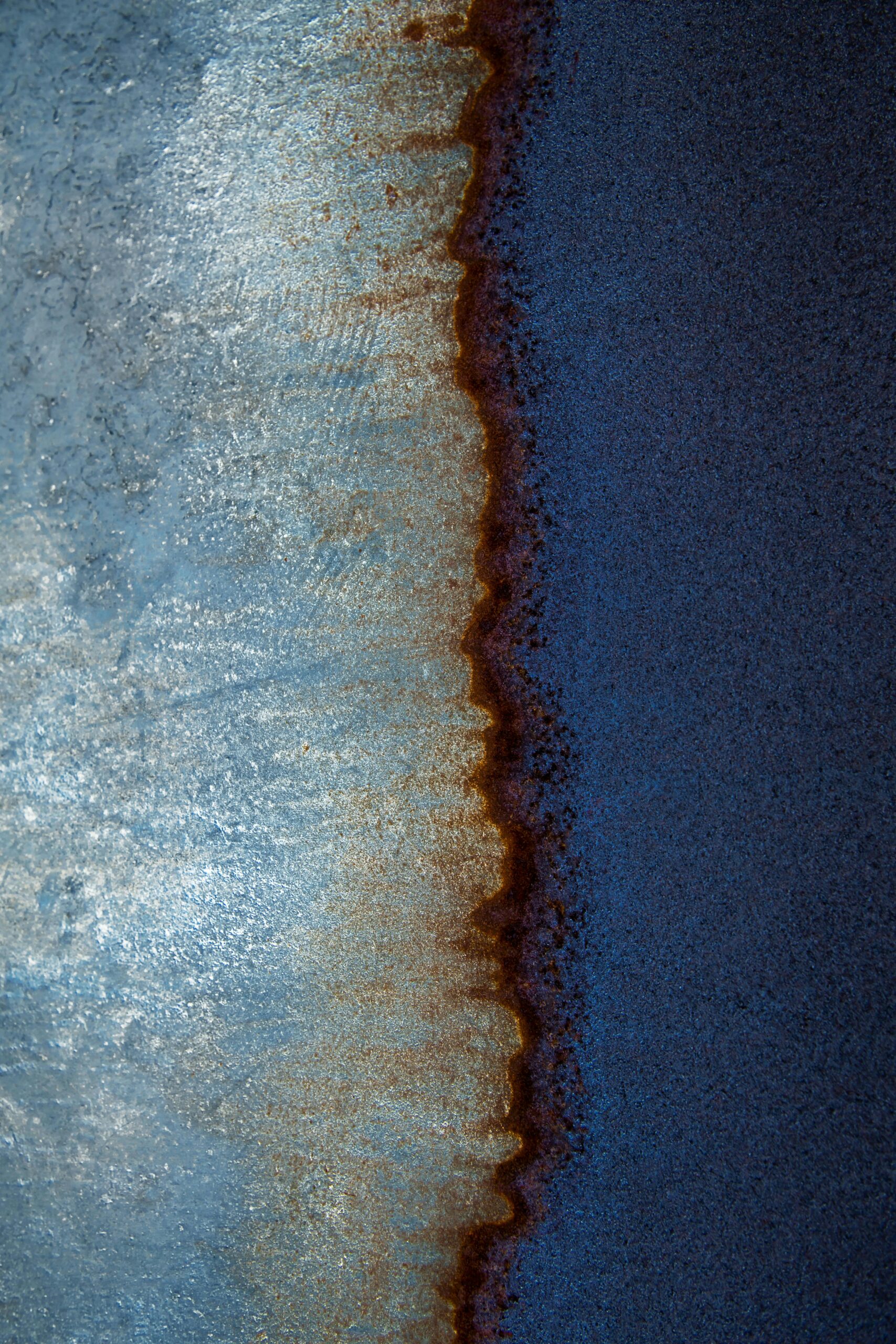 A striking abstract aerial view capturing the merging colors of the ocean and shoreline.